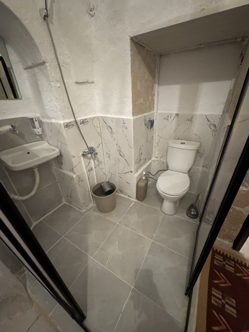 Mermer desenli seramik kaplı banyo; lavabo, duş ve klozet